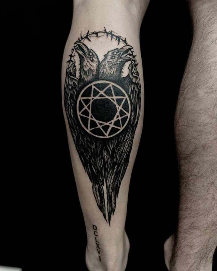 Lower leg tattoo featuring crows with a circular geometric design.