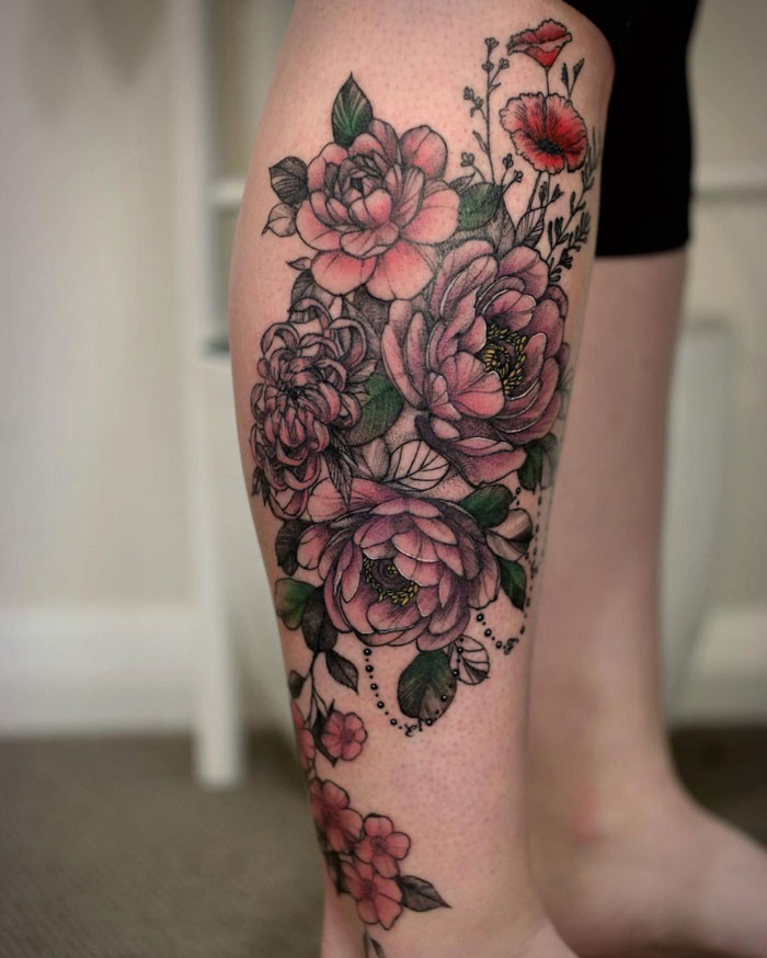 Floral calf tattoo showcasing pink and red flowers, embodying coolness and style.