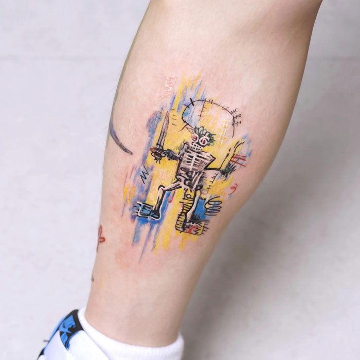 Unique calf tattoo featuring a colorful abstract skeleton design on a person's leg.