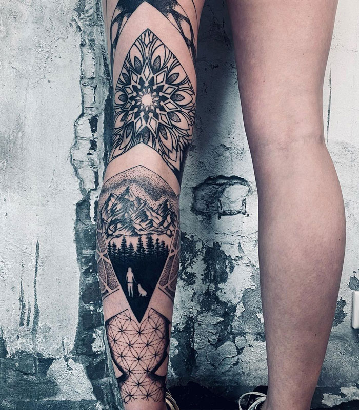 Intricate calf tattoo featuring geometric patterns, mountain landscape, and forest design on leg.