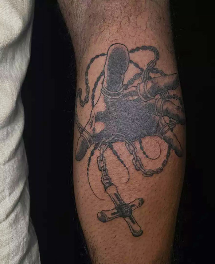 Calf tattoo featuring a realistic hand holding chains, showcasing intricate details and pure coolness.