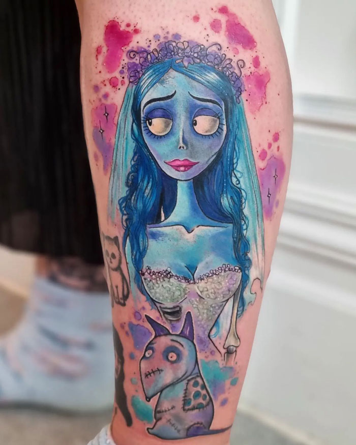 Unique calf tattoo featuring a blue-haired character and a small creature, with colorful background accents.