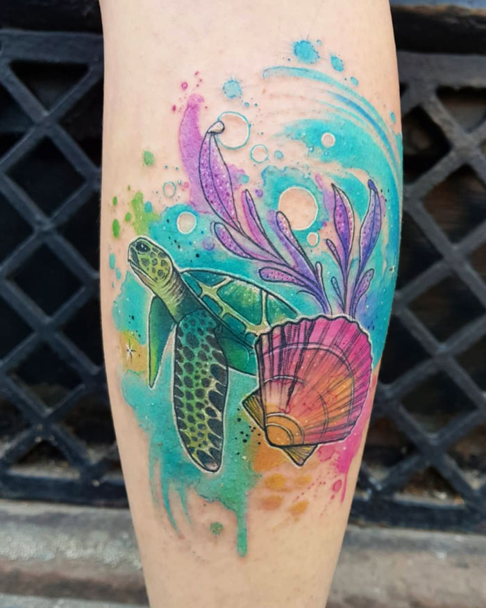 Colorful calf tattoo featuring a sea turtle, shell, and abstract waves in vibrant hues.