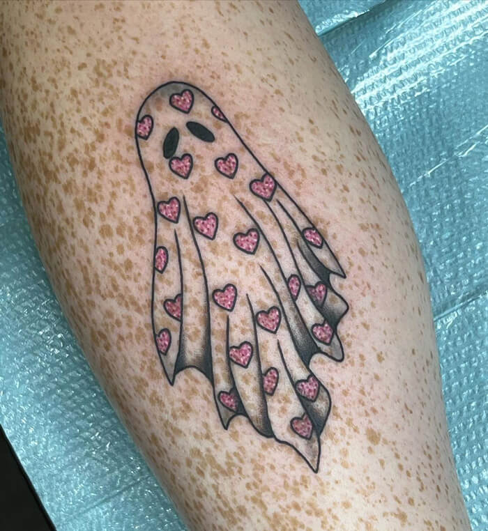 Lower leg tattoo featuring a ghost design with pink hearts.