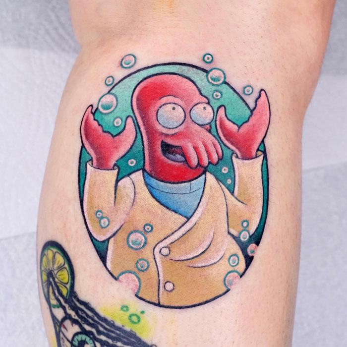 Colorful calf tattoo of a cartoon character surrounded by bubbles, showcasing cool tattoo artistry.