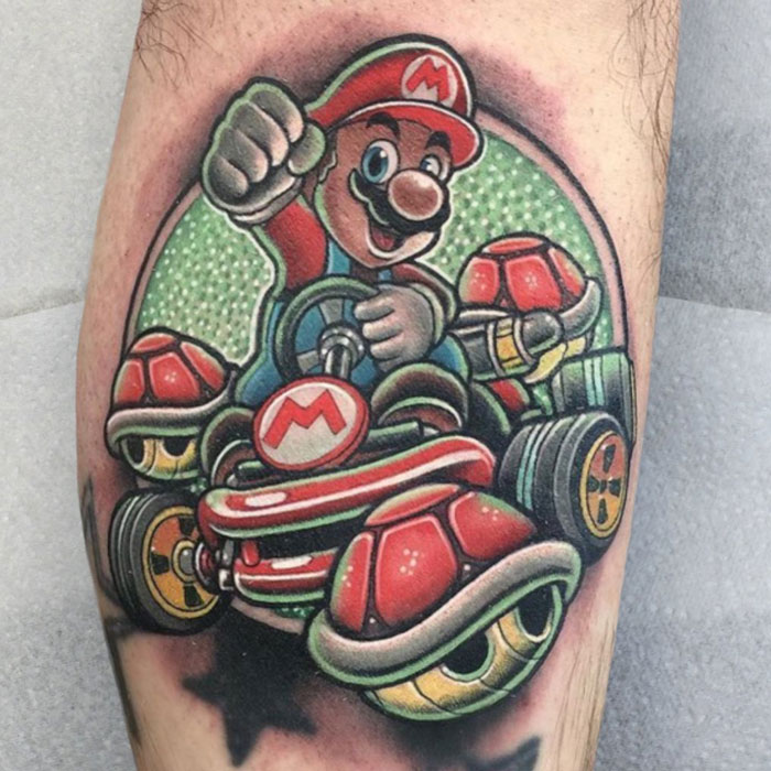 Lower leg tattoo featuring a vibrant character in a racing scene with red shells.