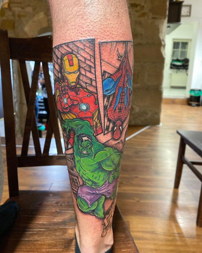 Lower leg tattoo featuring comic-style superheroes in vibrant colors.
