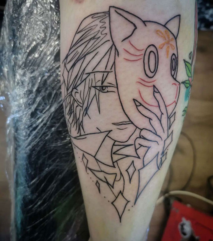 Anime-inspired lower leg tattoo featuring a character holding a mask.