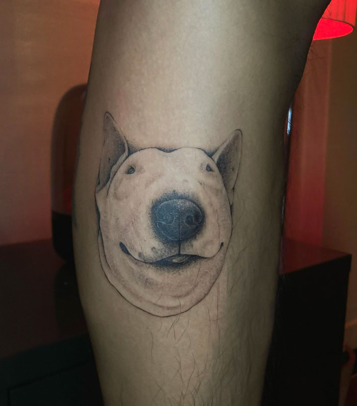 Calf tattoo of a detailed dog face showcasing cool tattoo art on skin.