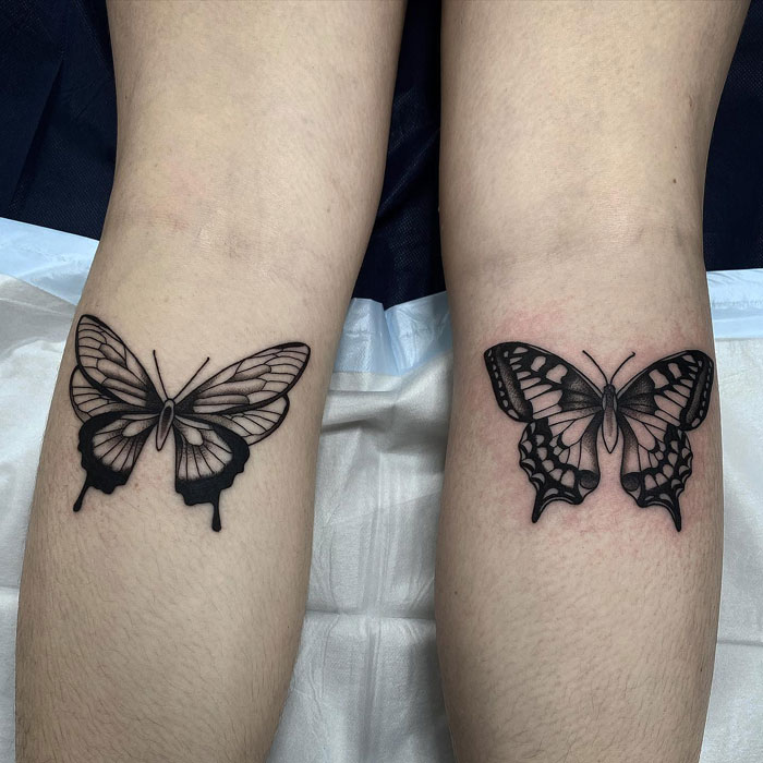 Butterfly lower leg tattoos featuring detailed black ink designs on both legs.