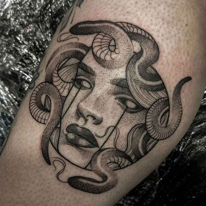 Calf tattoo featuring an intricate face with snakes, showcasing cool and unique tattoo design ideas.