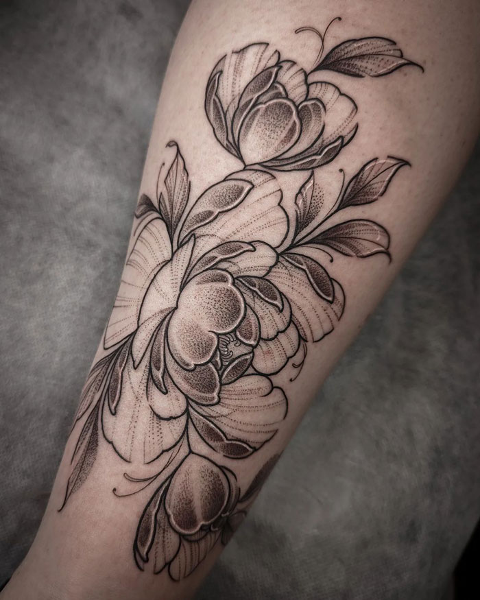 Floral calf tattoo showcasing intricate shading and linework.