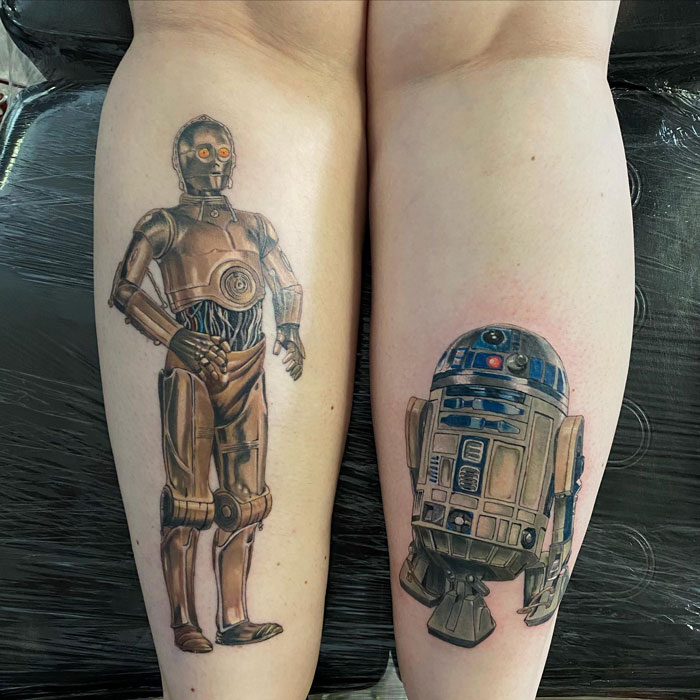 Lower leg tattoos featuring two iconic robots from a popular sci-fi franchise.