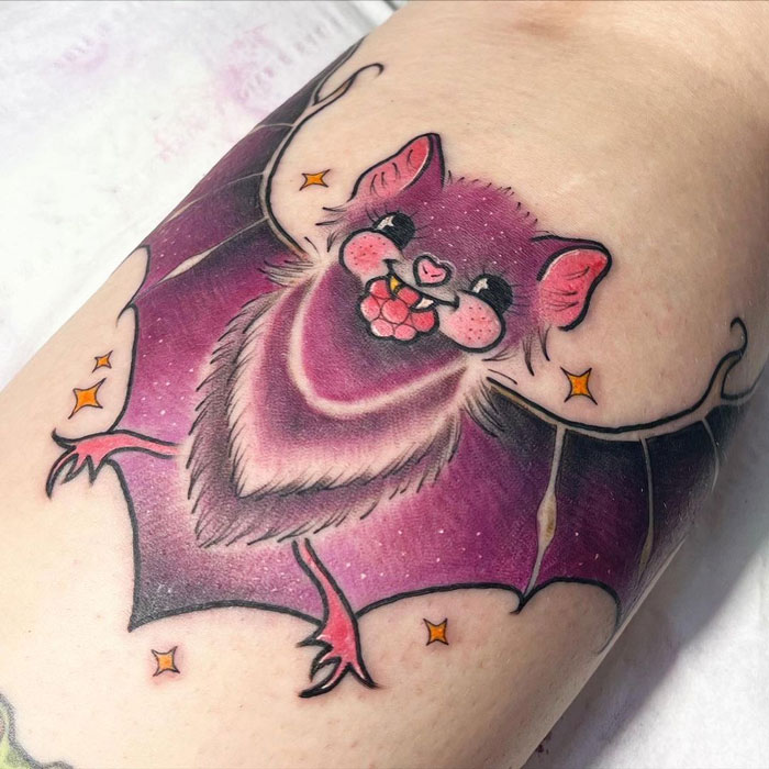 Cute bat-themed calf tattoo with vibrant colors and playful design.