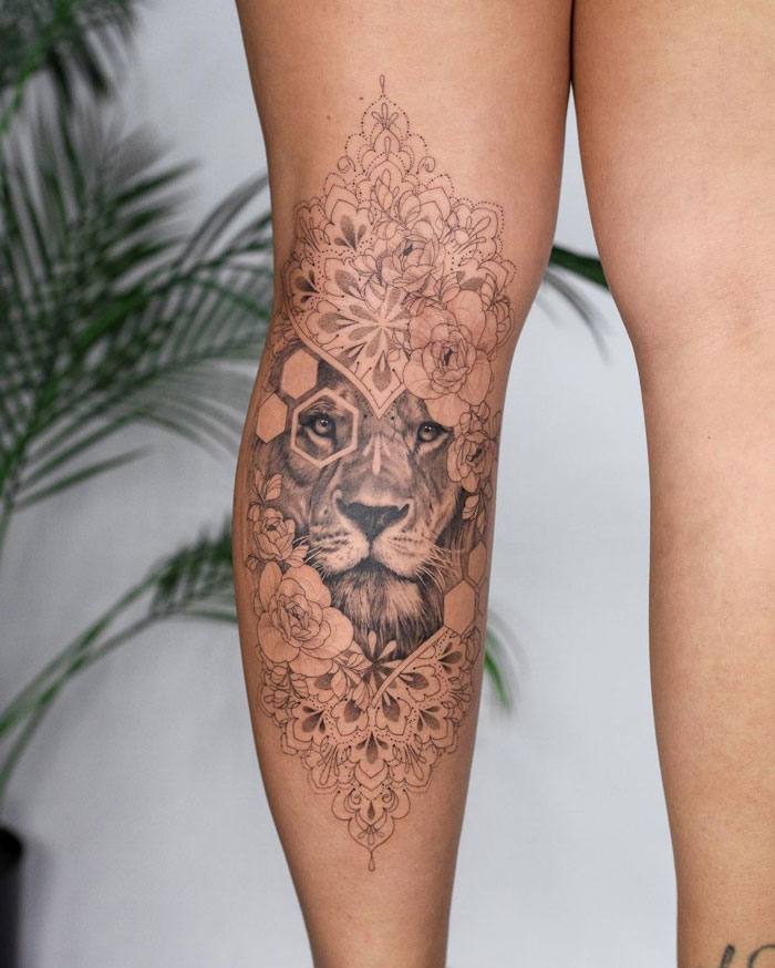 Lower leg tattoo featuring an intricate lion and floral mandala design.