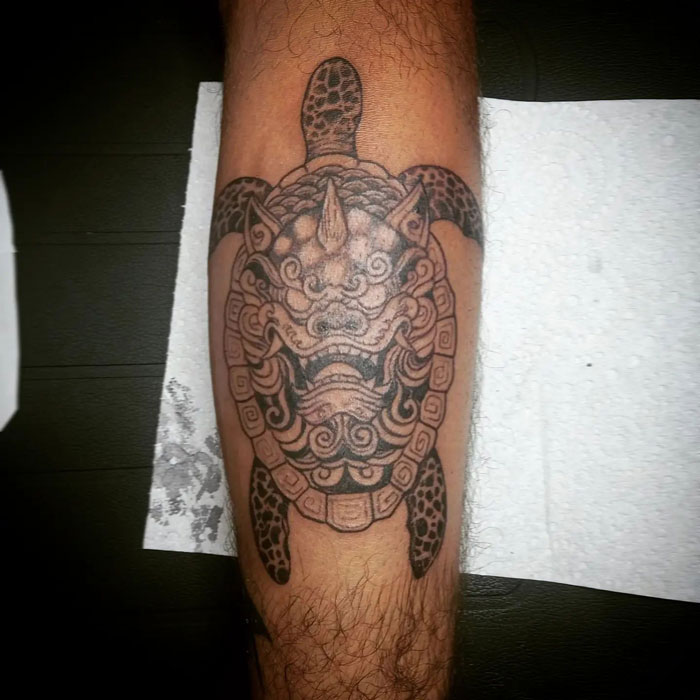 Tattoo of an intricate mythical turtle design on a calf, showcasing cool tattoo artistry.
