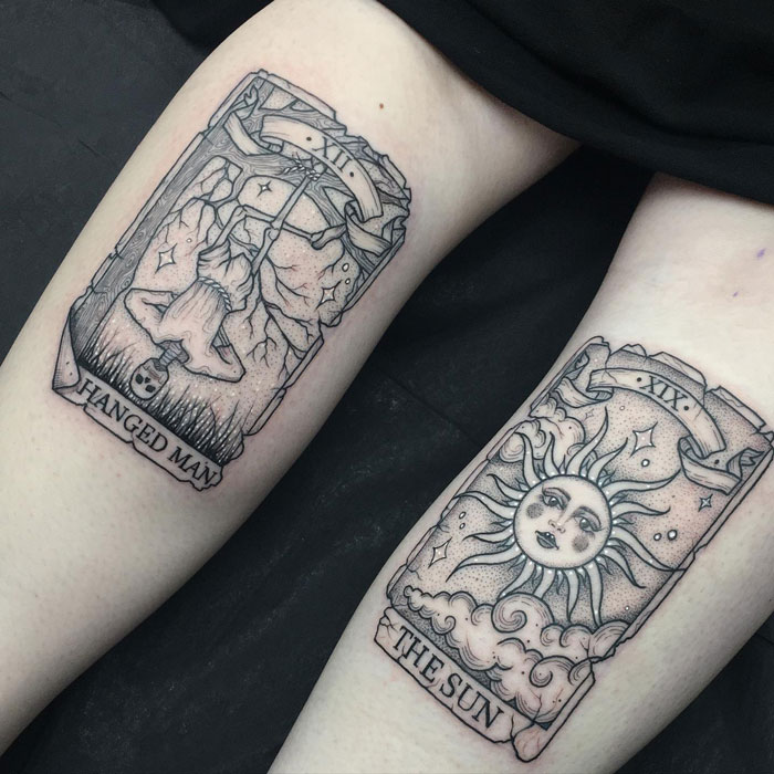 Tarot-inspired calf tattoos featuring The Hanged Man and The Sun cards, showcasing coolness and creativity.