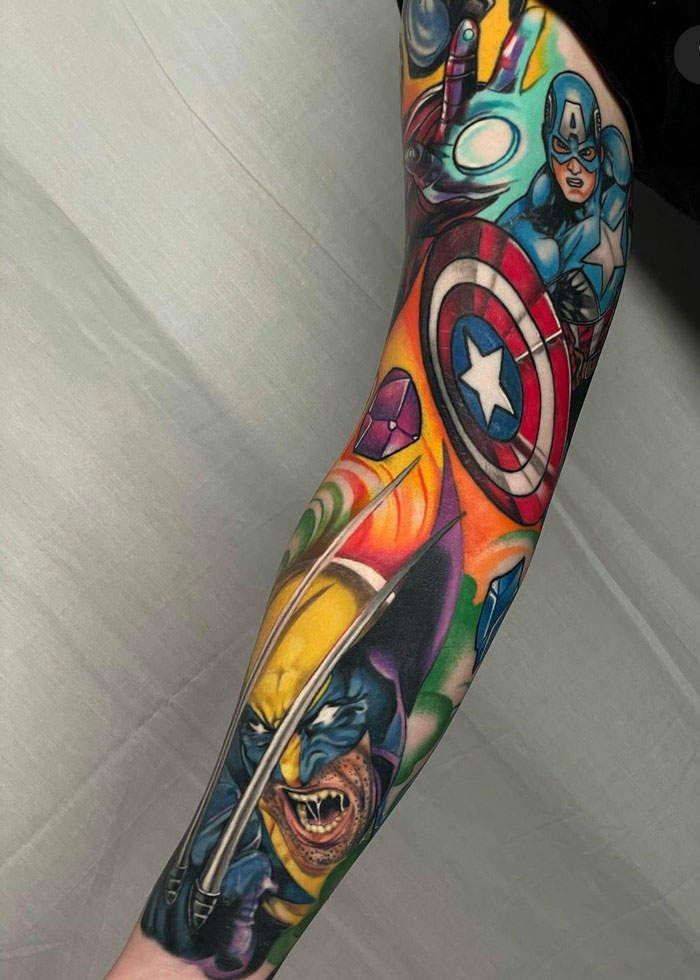 Colorful Marvel tattoos featuring Captain America and Wolverine on an arm.