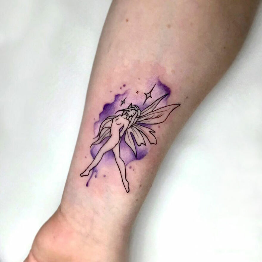 Watercolor tattoo of a fairy with purple wings on an arm.