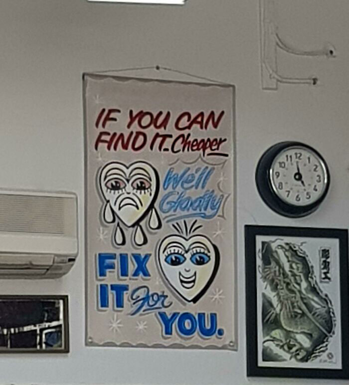Tattoo shop sign reading "If you can find it cheaper, we'll fix it for you" with a clock and a dragon sketch on the wall.