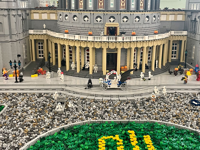 Detailed LEGO build of a grand building with skeleton figures and a green area, showcasing incredible LEGO art skills.