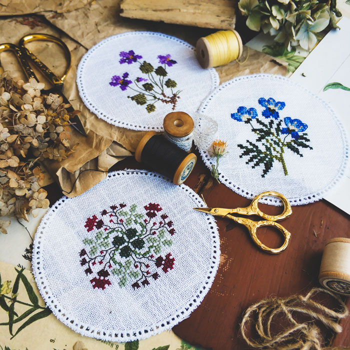Embroidery projects with floral designs at home, surrounded by threads and scissors, perfect for avoiding boredom.