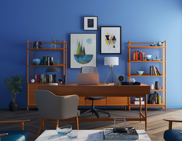 Modern home office with blue wall, art, wooden shelves, and desk; find creative ways to avoid boredom at home.
