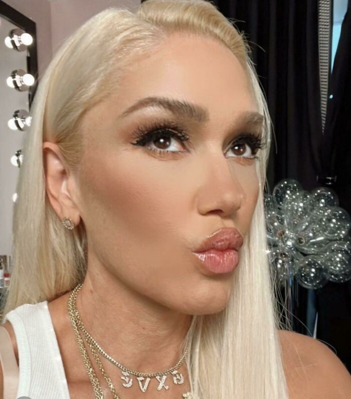 Close-up of a woman with makeup and blonde hair, posing for a selfie related to Instagram reality fake pics.