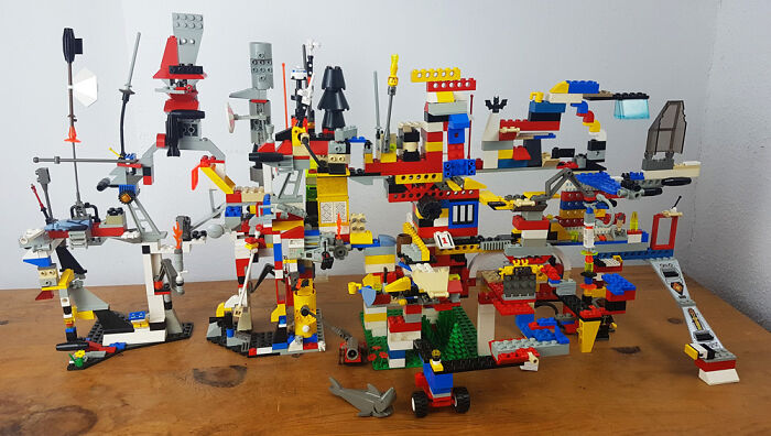 Colorful and intricate LEGO builds arranged on a wooden table showcasing incredible creativity and detail in art form.