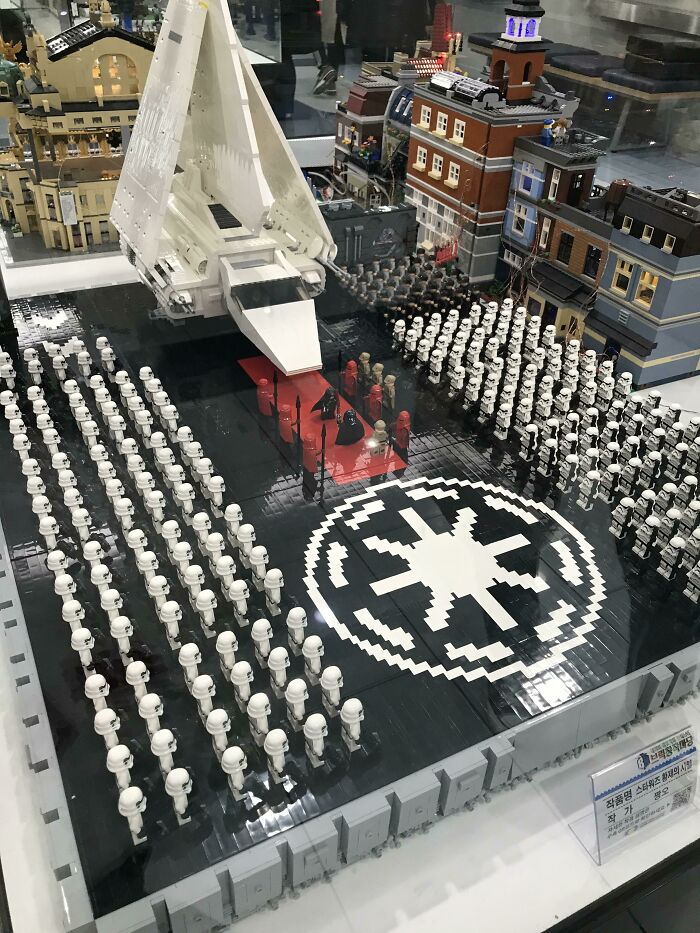 LEGO Star Wars scene featuring a large army of stormtroopers and a white spaceship in a detailed cityscape build.