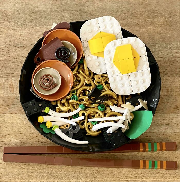 Intricate LEGO builds of a food dish featuring eggs, noodles, and chopsticks, showcasing incredible LEGO art craftsmanship.