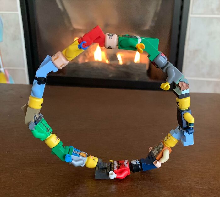Colorful LEGO mini-figures creatively linked to form a ring, showcasing incredible LEGO builds as real works of art.