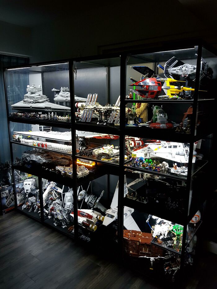 Display case filled with intricate LEGO builds featuring detailed Star Wars spaceships, showcasing incredible artistic skill.