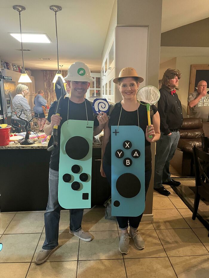 Two people dressed as Nintendo Switch controllers at a party, showcasing creative Halloween costumes and fun gaming props.