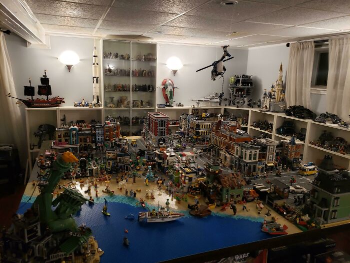 Intricate LEGO builds displayed in a room, showcasing detailed and creative LEGO city and art scenes with mini figures.
