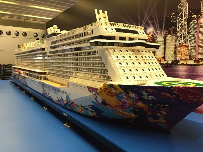 Large intricate LEGO build of a cruise ship displayed indoors, showcasing detailed and incredible LEGO art craftsmanship.