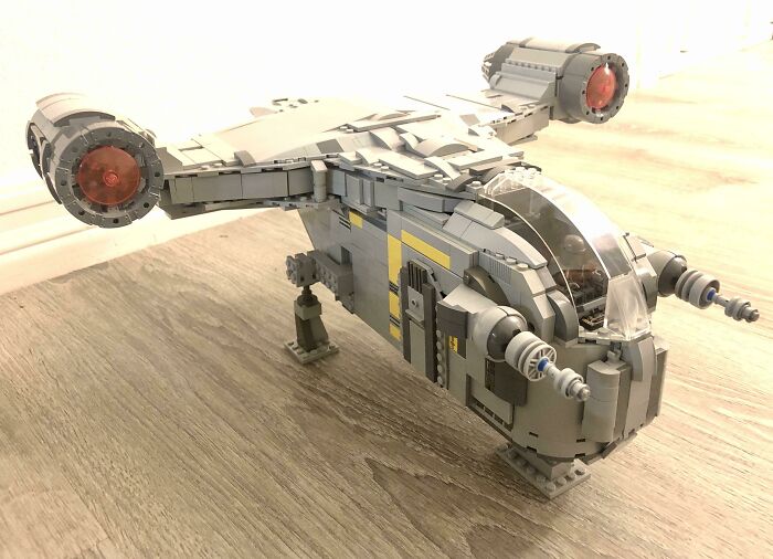 Detailed LEGO build of a futuristic aircraft displayed on a wooden surface, showcasing impressive LEGO art techniques.