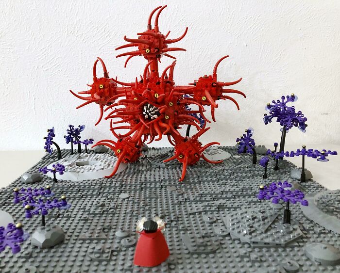 Intricate LEGO builds featuring a red spiky structure with purple plants on a gray baseplate, showcasing incredible LEGO art.