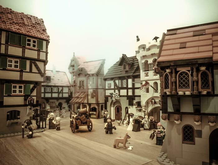 Incredible LEGO builds depicting a detailed medieval village scene with minifigures and intricate architecture.