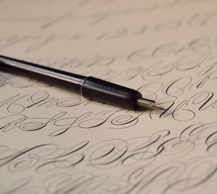 Calligraphy practice with fountain pen on paper, showcasing fun things to do at home.