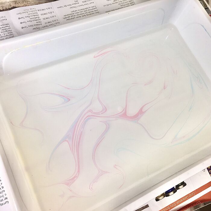 Marbling design with pink and blue swirls in a white tray, illustrating the Sernakkab technique. Marbling design with pink and blue swirls in a white tray, illustrating the Sernakkab technique.