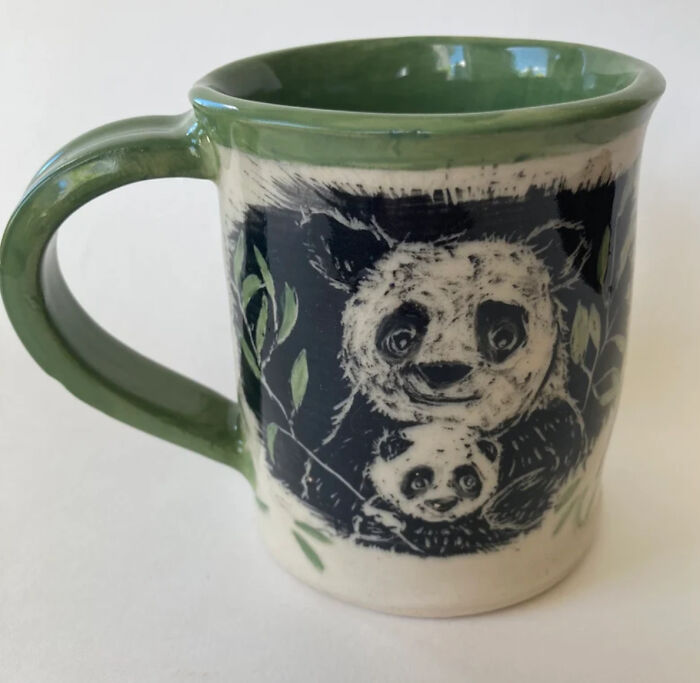 A Panda And Her Cub Munch Contentedly On Bamboo Leaves