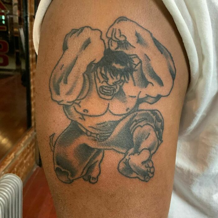 Marvel tattoo of a muscular character on an arm, showcasing power and intensity.