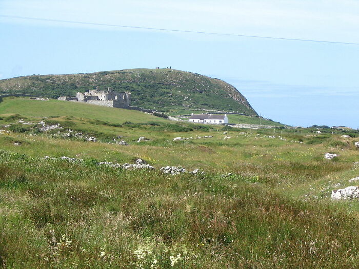 the field with the castle and the house near the hill