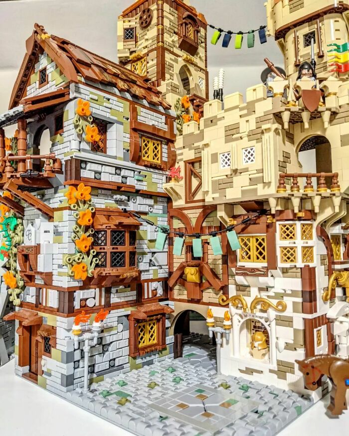 Intricate LEGO builds showcasing medieval-style buildings with detailed architecture and decorative elements in a vibrant display.