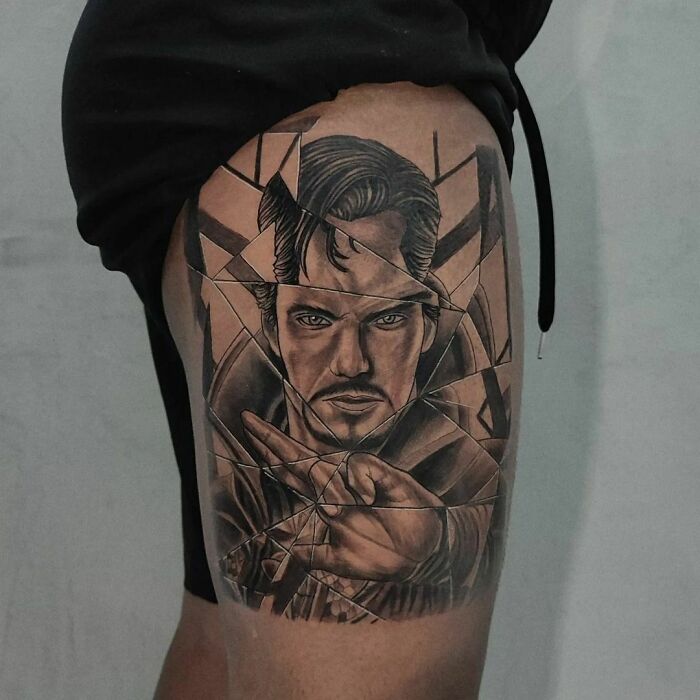 Marvel-inspired tattoo of a superhero Dr. Strange with a fragmented design on a person's thigh.