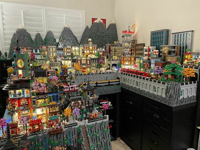 Intricate LEGO builds featuring a detailed cityscape with mountains, trains, and illuminated buildings as real works of art.