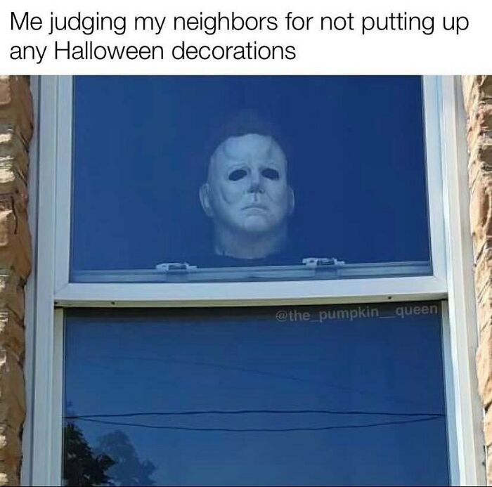 Spooky Halloween meme with a masked figure looking out a window, judging neighbors for no decorations.