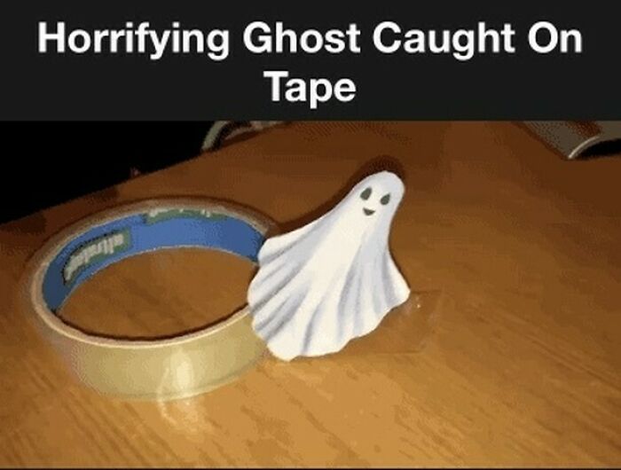 Hilarious ghost meme with a small ghost figure next to tape roll on a table.
