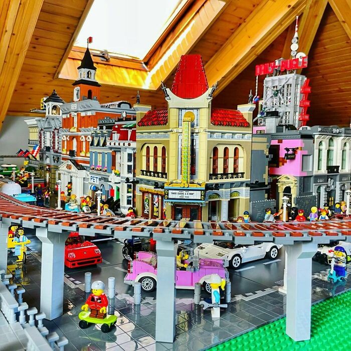 Intricate LEGO builds of a cityscape featuring buildings, vehicles, and minifigures in a detailed artistic display.